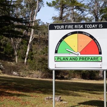A sign reads "Your fire risk today is" and has the arrow pointing to the far left green section. Below text on the sign reads that this indicates to "plan and prepare".
