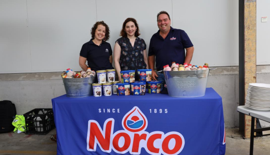 A photo of Norco staff standing behind a table covered with dairy produce