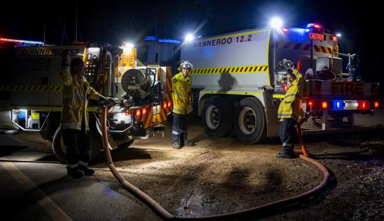 Firefighters stand around firetrucks at night. Image taken by Morten Boe.
