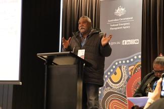 A man behind a lectern addresses the audience at Exercise Convergence 2025