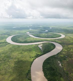 Aerial photo of Adelaide River, a squiggle on a lush green landscape.