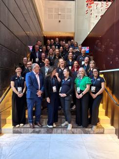 Large group photo on a slight of stairs in an office, including Bec, Joe Buffone, and the Branch.