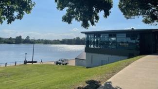 Photo of the rowing club built into a grassy hillside by the river.