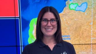 Photo of Drusilla in front of a screen with a map of Australia.