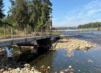 An image of the Great River Walk in Penrith. It shows the raised walkway next to a river.