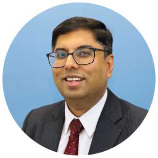 Headshot of Sanandan with light blue background, cropped to a circle.